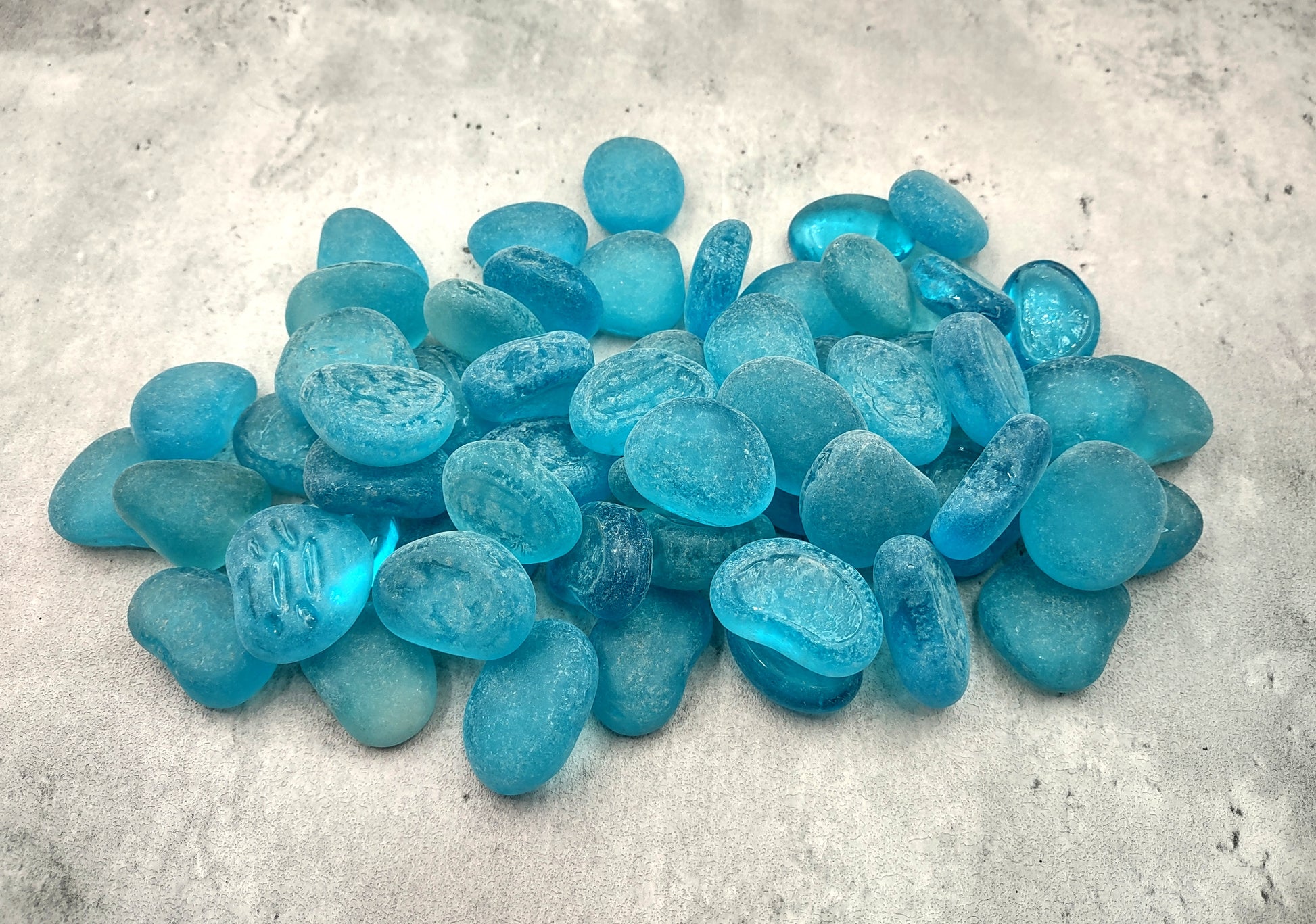 Beach Sea Glass Rounded Turquoise Blue Frosted Tumbled Pebbles (approx. 1 Kilogram or 2.2 lbs. 1-1.5 inch). Pile of blue turquoise Beach Glass pebbles. Copyright 2024 SeaShellSupply.com.