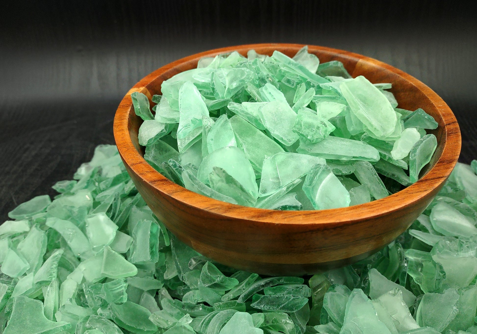 Photo of 10 pound pile of bottle green sea glass. Copyright 2024 Seashellsupply.com.