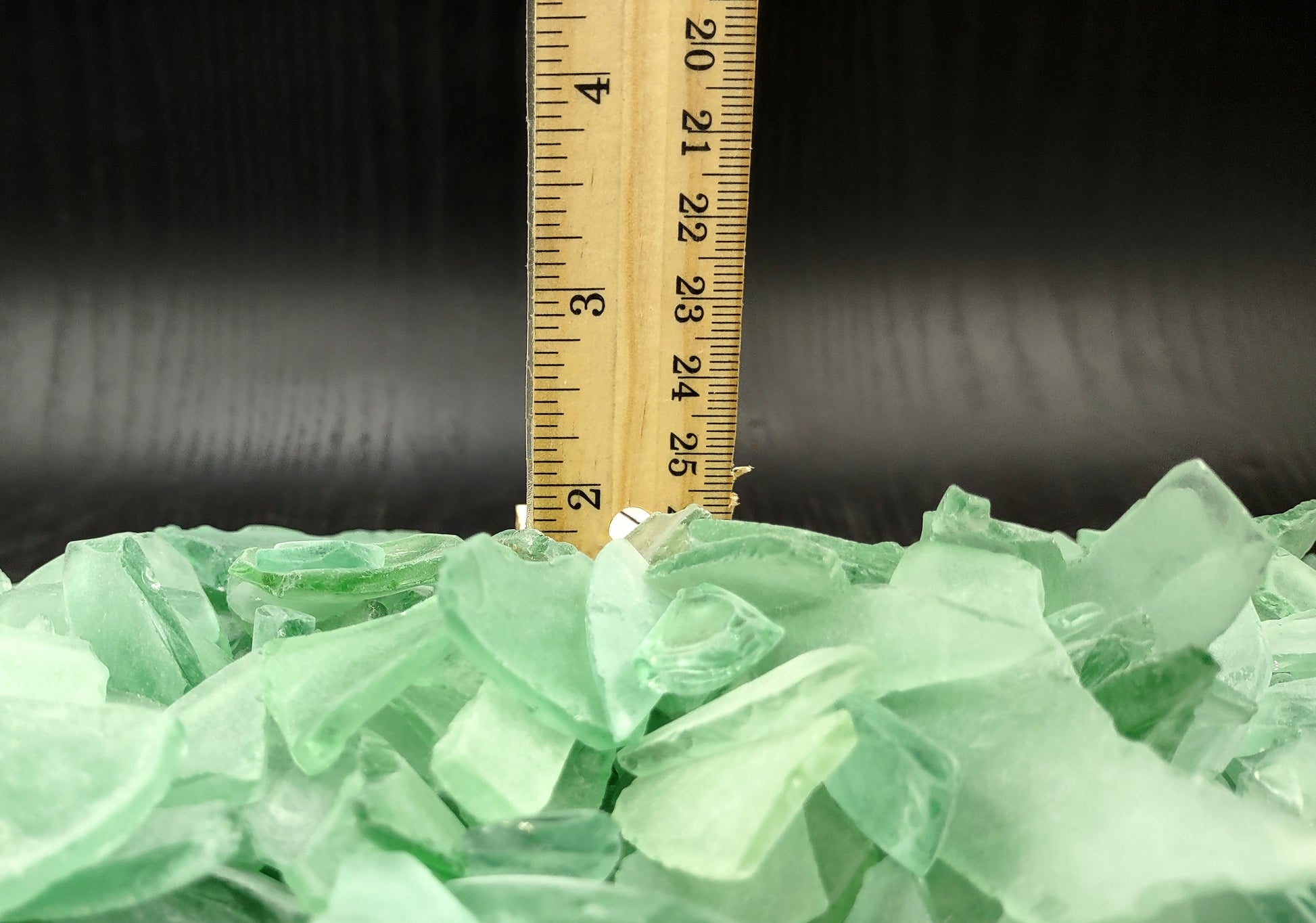 Photo of 10 pound pile of bottle green sea glass. Copyright 2024 Seashellsupply.com.