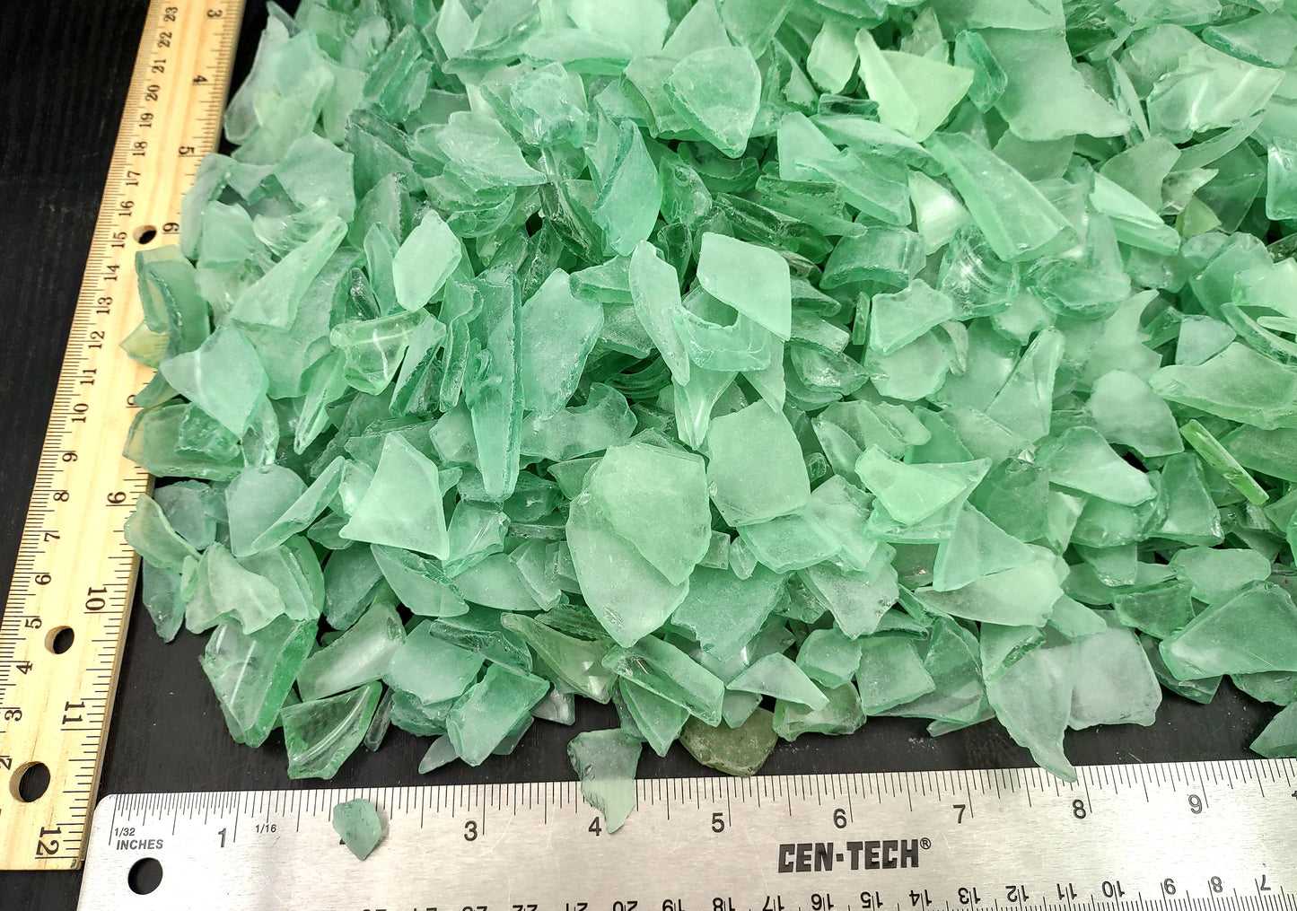 Photo of 10 pound pile of bottle green sea glass. Copyright 2024 Seashellsupply.com.