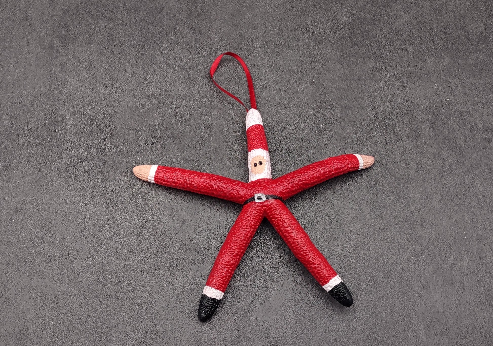 Red Linckia Starfish Santa Ornament (1 seastar approx. 4-6 inches)  on green background. Copyright 2022 SeaShellSupply.com.