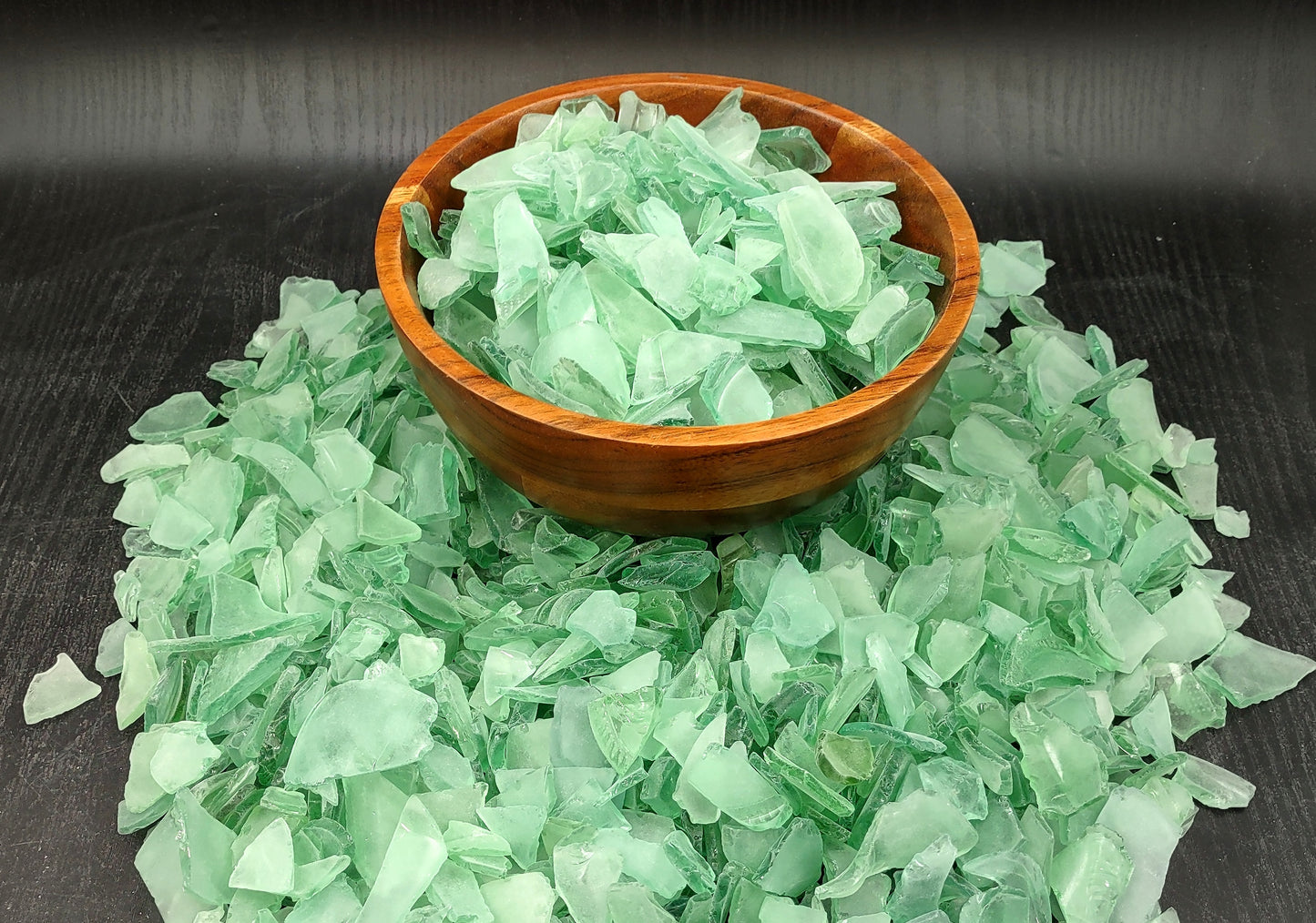 Photo of 10 pound pile of bottle green sea glass. Copyright 2024 Seashellsupply.com.