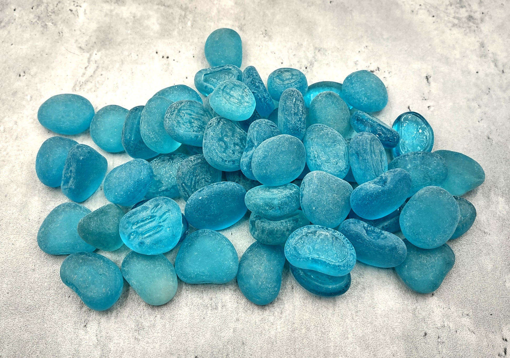 Beach Sea Glass Rounded Turquoise Blue Frosted Tumbled Pebbles (approx. 1 Kilogram or 2.2 lbs. 1-1.5 inch). Pile of blue turquoise Beach Glass pebbles. Copyright 2024 SeaShellSupply.com.