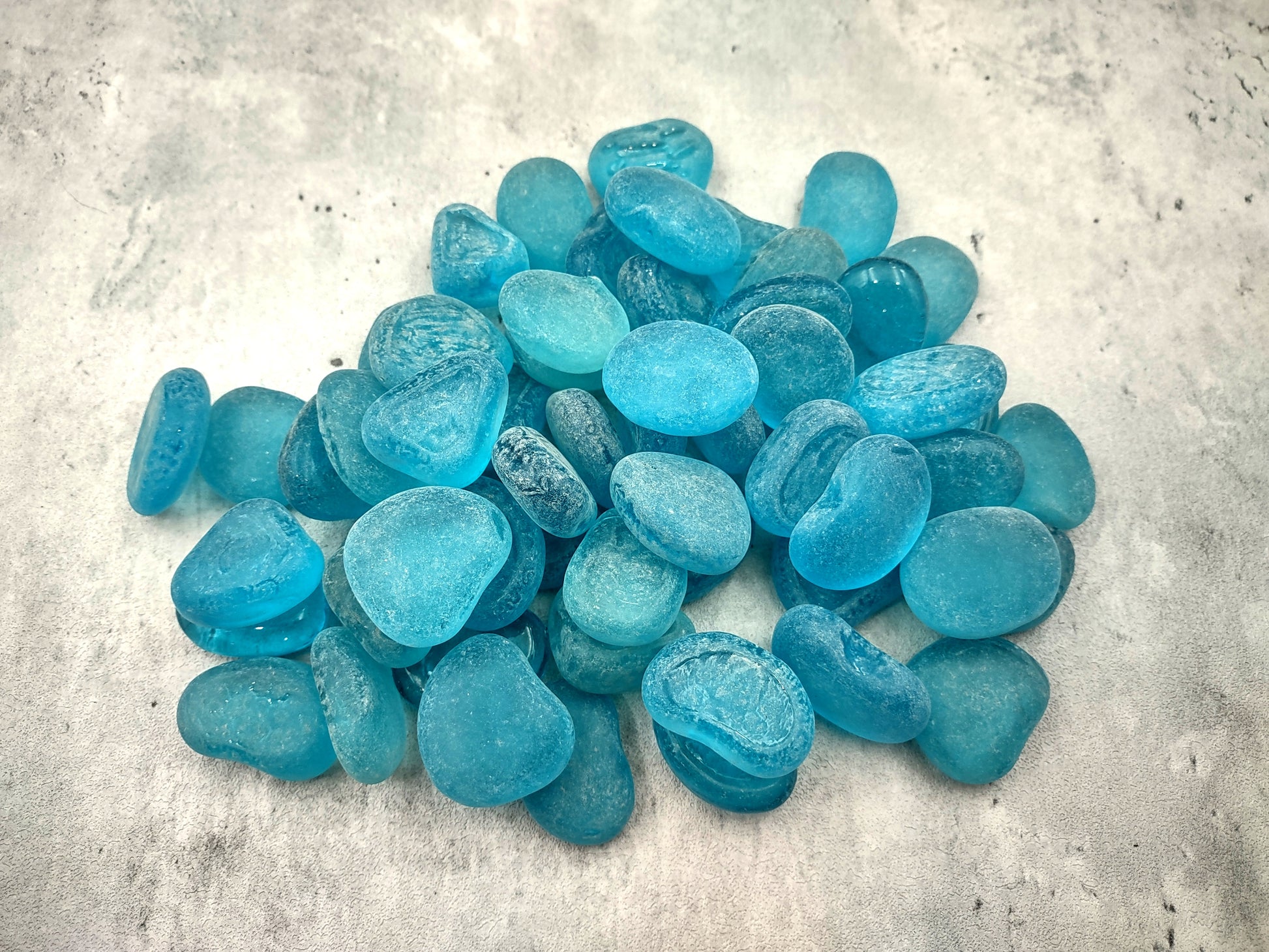 Beach Sea Glass Rounded Turquoise Blue Frosted Tumbled Pebbles (approx. 1 Kilogram or 2.2 lbs. 1-1.5 inch). Pile of blue turquoise Beach Glass pebbles. Copyright 2024 SeaShellSupply.com.