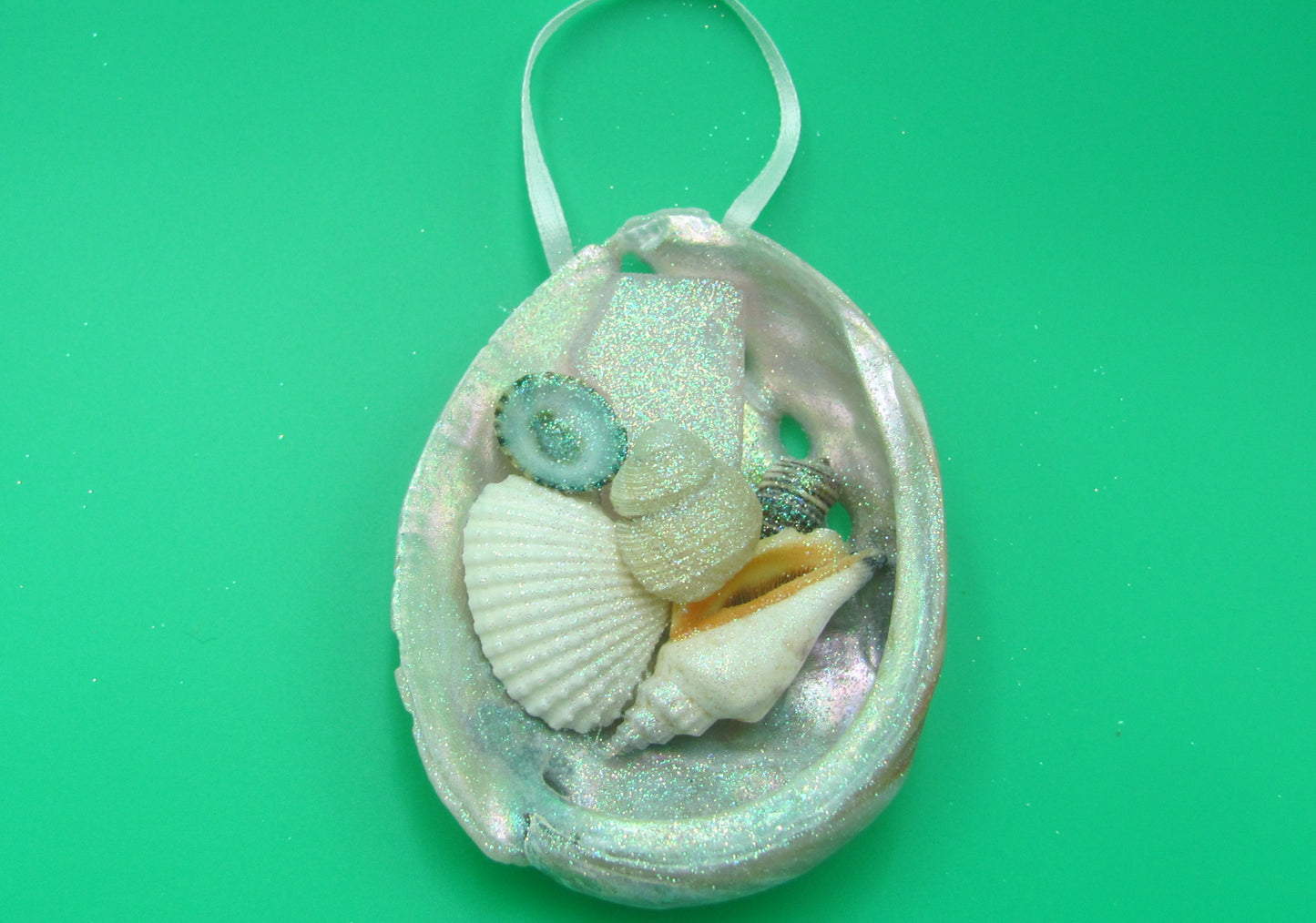 Abalone Frosted Sea Glass Ornament (1 star approx. 3-4 inches) on green background. Copyright 2022 SeaShellSupply.com.