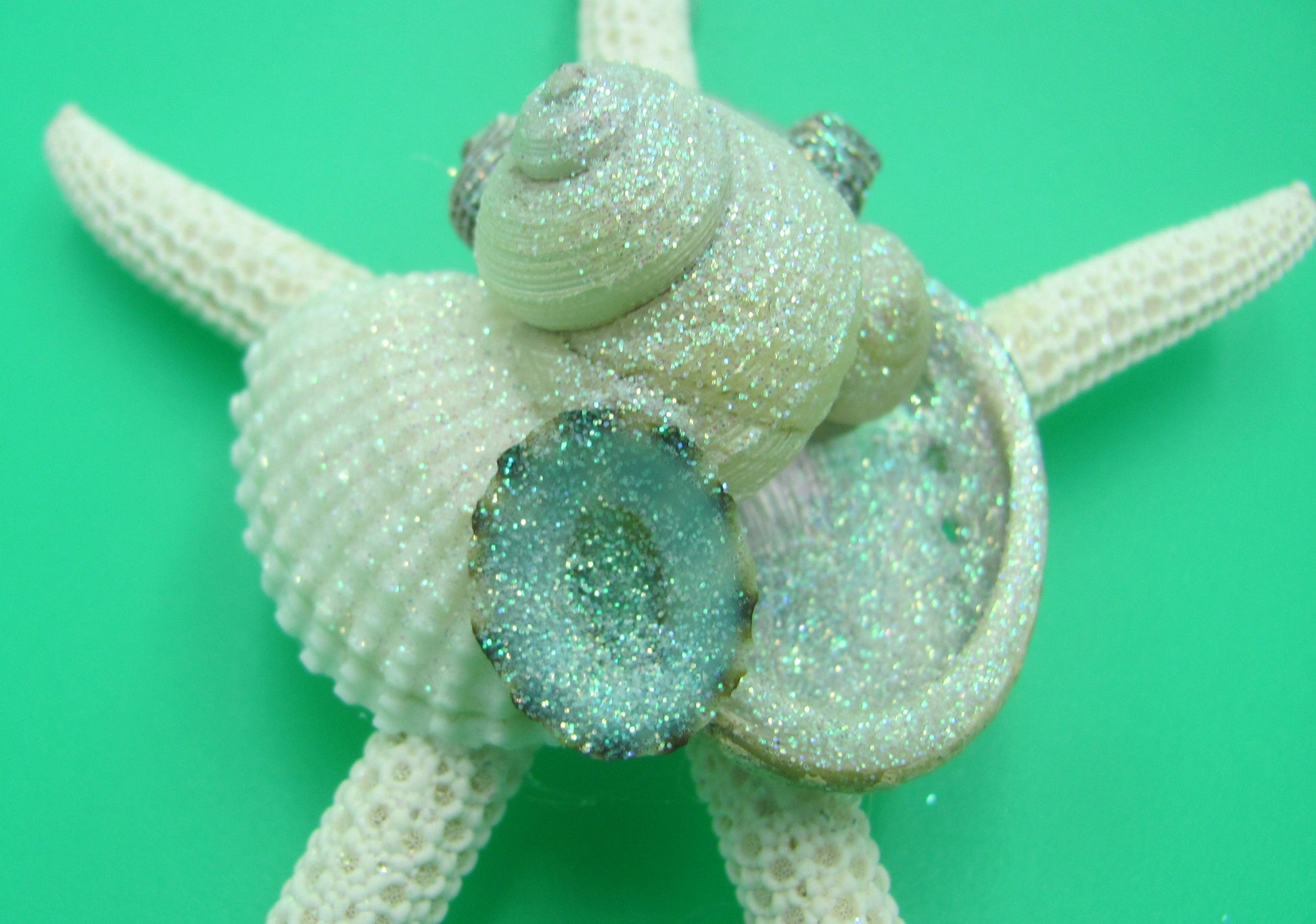 Frosted Seaglass Linckia Starfish Ornament (1 seastar approx. 4-6 inches) on green background. Copyright 2022 SeaShellSupply.com.